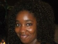 A neck up headshot of DeLynda Lindsey against a dark background.