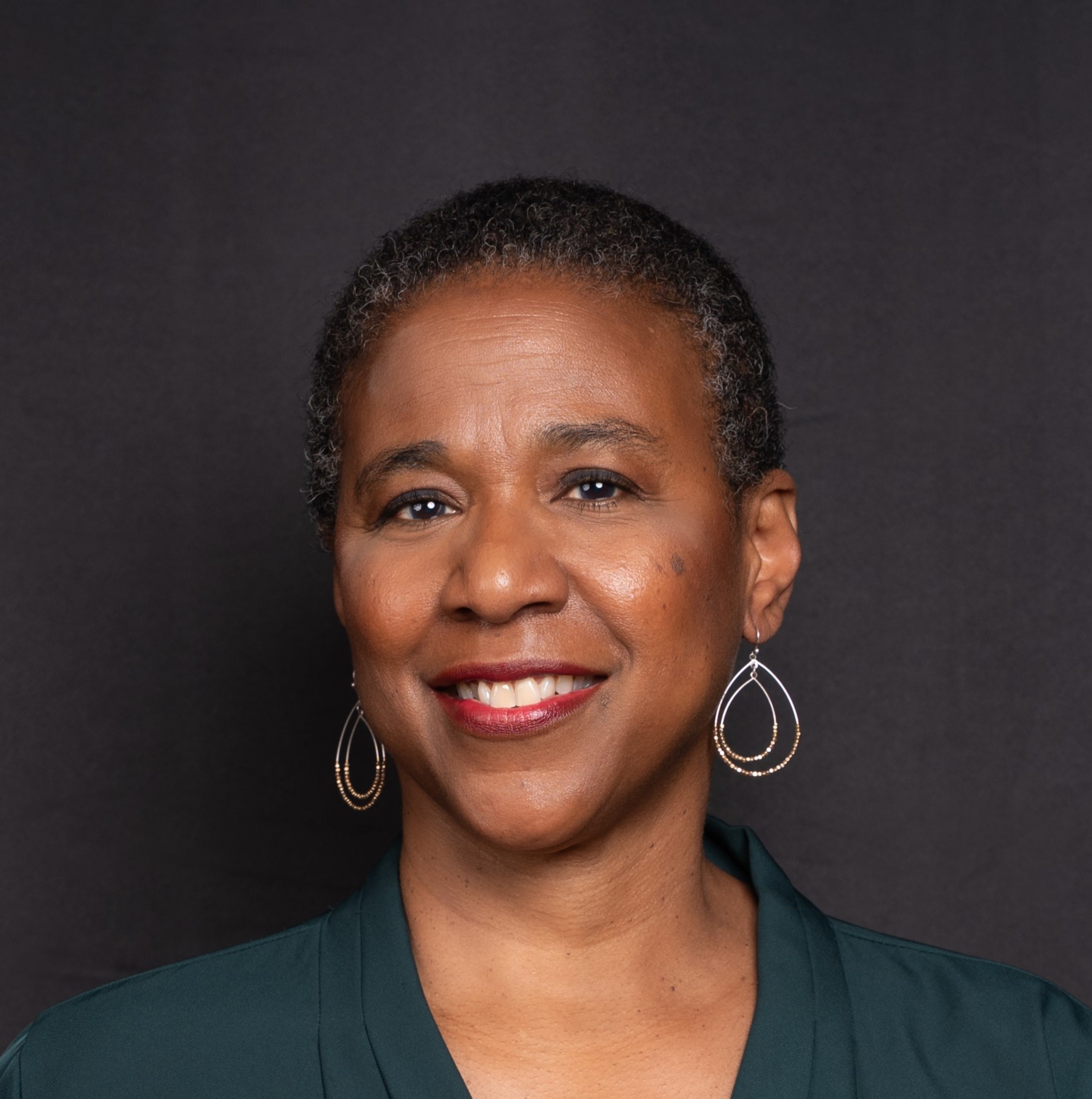 headshot of smiling woman in green shirt
