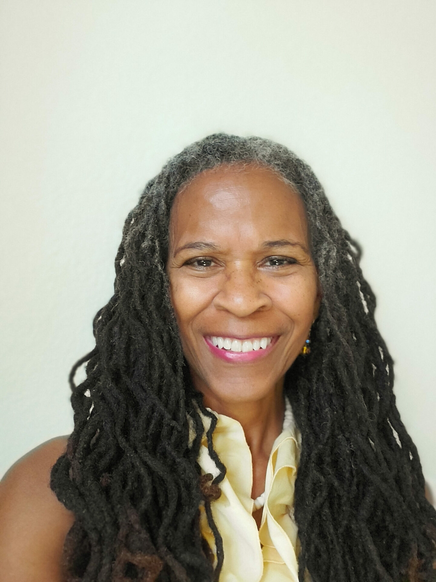 A headshot of Cheryl Fields against a neutral beige background.