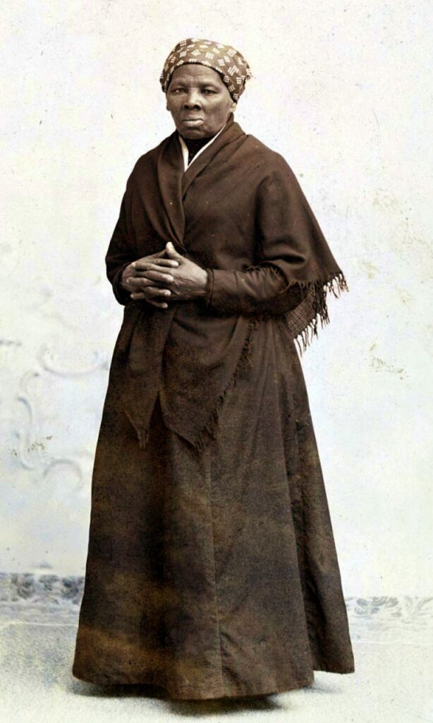 Black & white photo of Harriet Tubman wearing a dark wrap and a printed headscarf