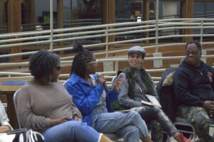 four bootcamp participants, three women one man, talk while seated in a circle