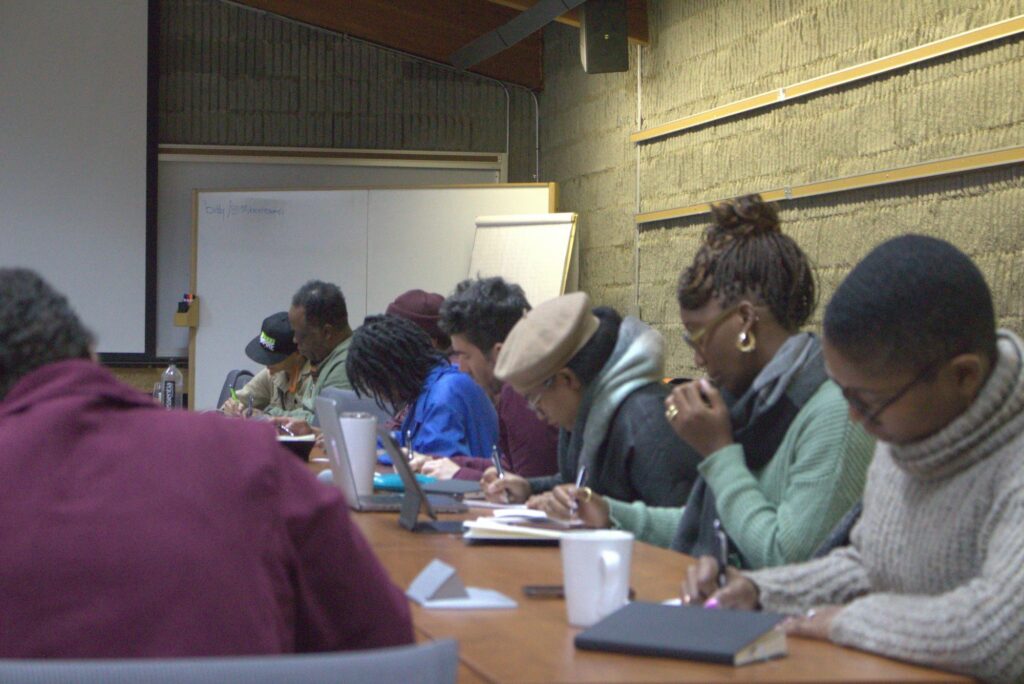 row of bootcamp participants working on a desk