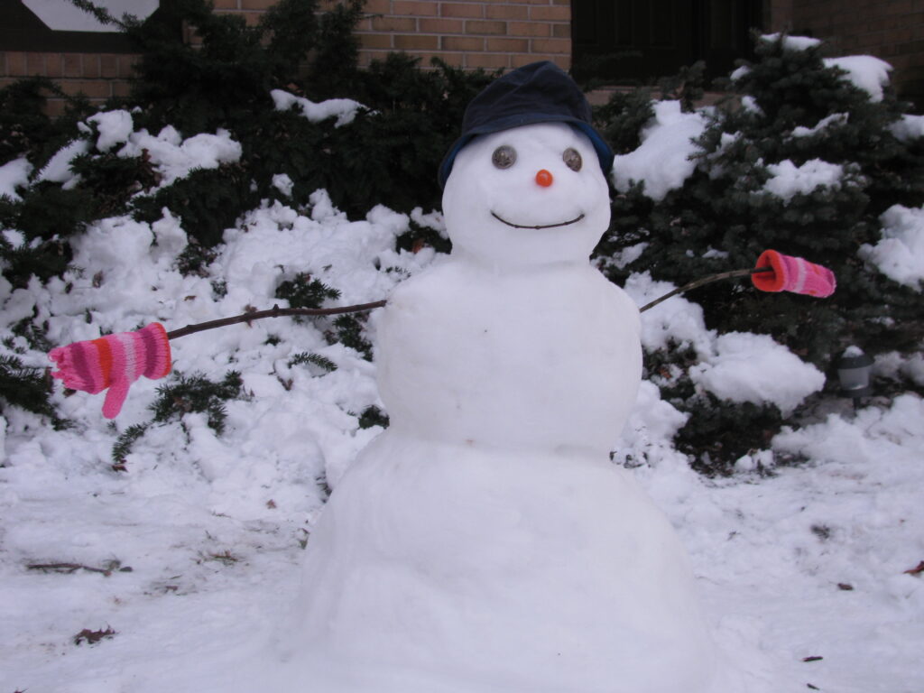 a smiling snowman with a black hat and pink gloves