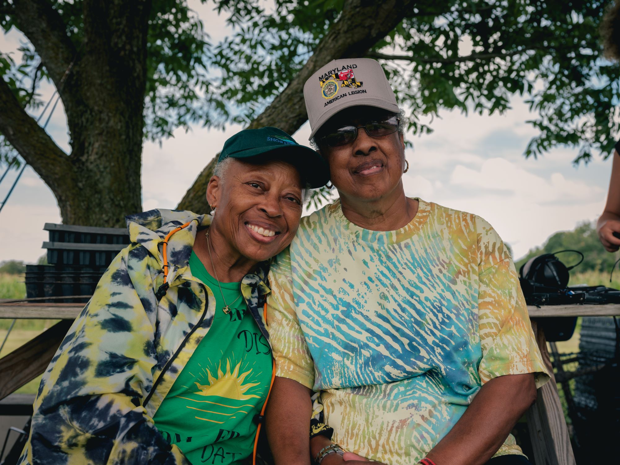 photo of two black women farmers sitting under a tree on their farm