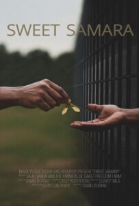 one hand passing a seed to another hand which is behind bars.