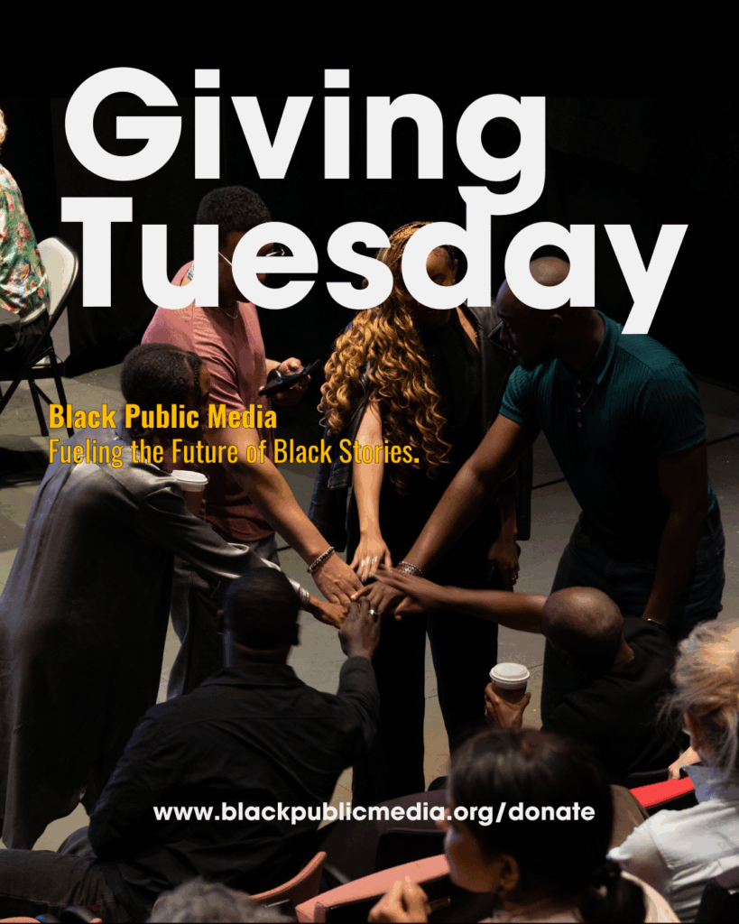 a circle of media makers pile their hands atop one another in solidarity.